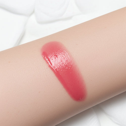 Natural skin swatch of Kalee Beauty Peach 2-in-1 Lip Oil & Cheek Tint showing sheer, dewy pigment on skin tone.